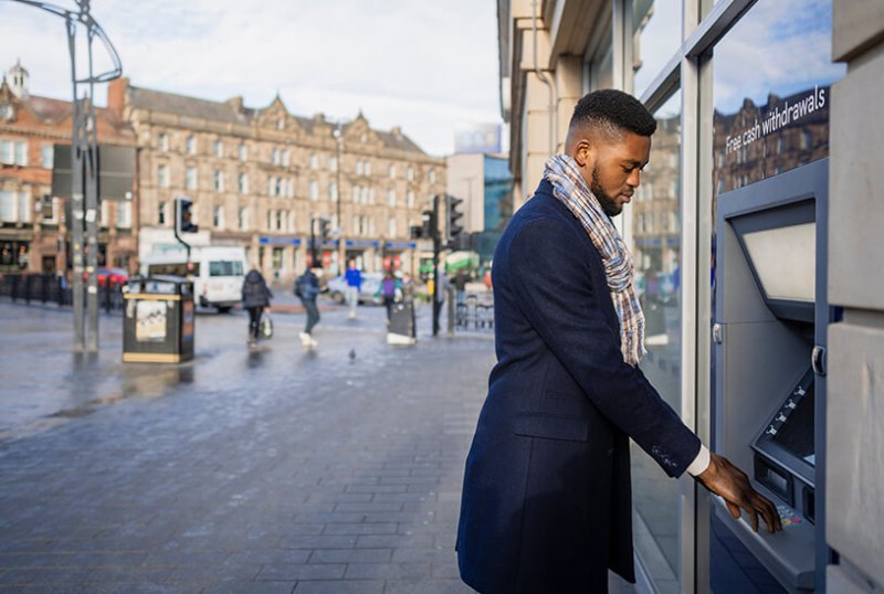 Business owner depositing cash in a cash machine