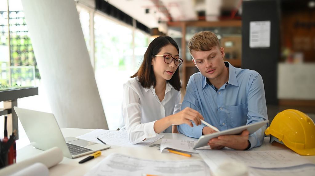Male and female civil engineers looking over a report