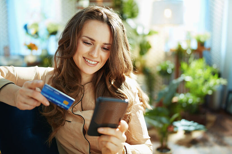 A consumer shopping online, using her credit card to buy something on her phone