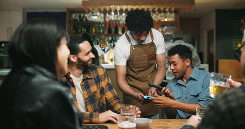 A group of customers order drinks in the pub