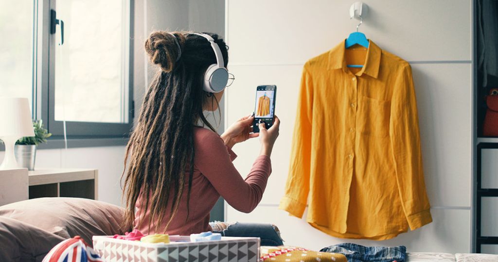 A Vinted seller takes photos of her clothes to sell as a side hustle
