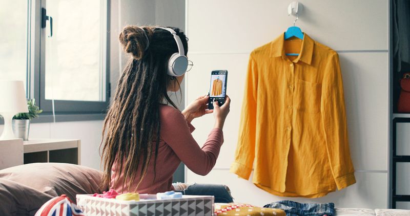A Vinted seller takes photos of her clothes to sell as a side hustle