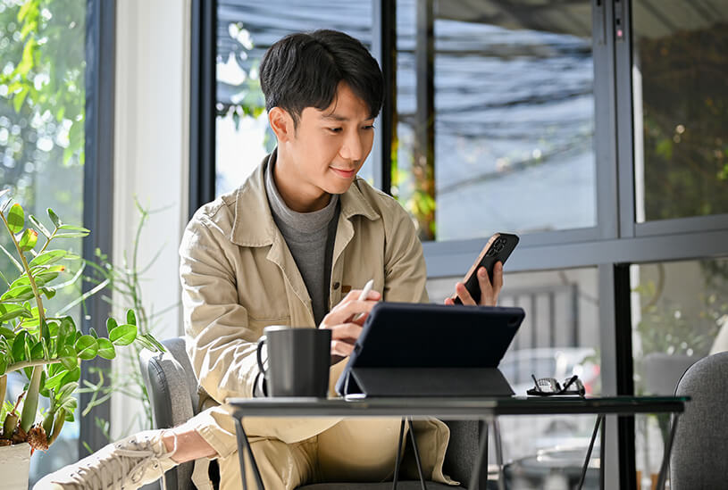 Business owner looking at tablet and phone