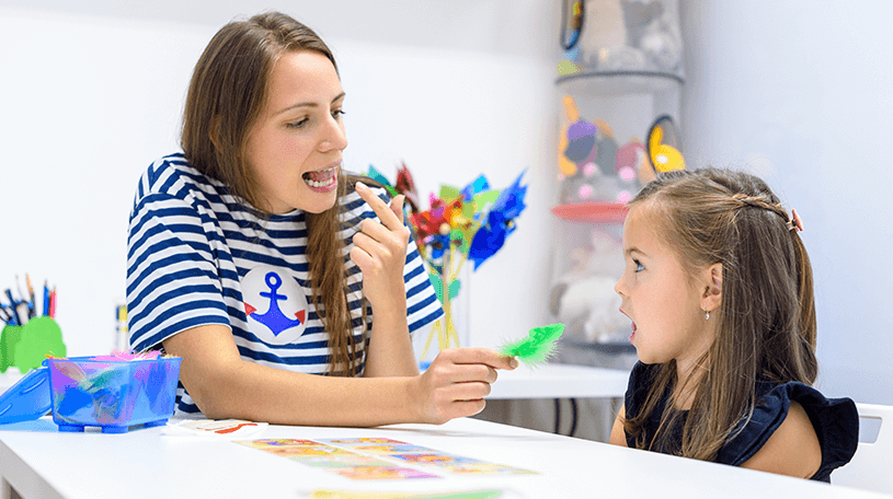 A speech therapist helping a child speak